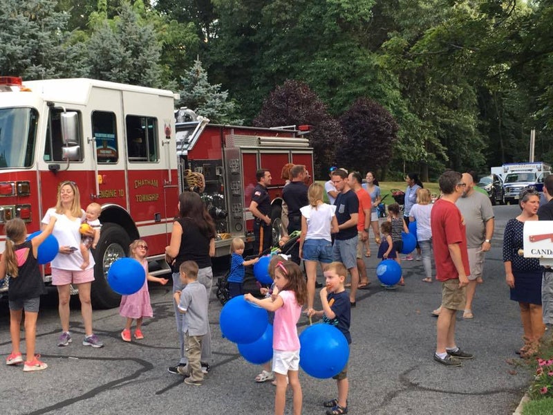 Families and children playing with balloons and socializing next to a firetruck in Chatham Township, NJ