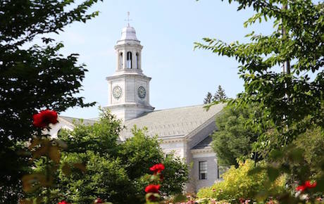 View of top of Madison Borough Courthouse through flowers and bushes